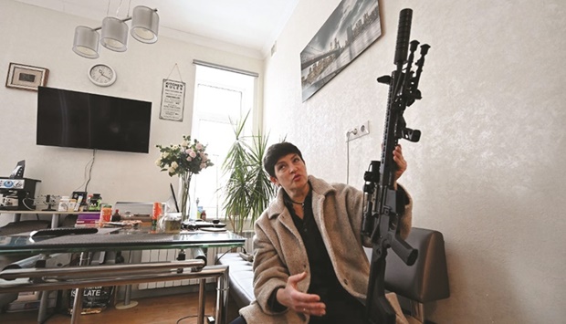 Mariana Zhaglo holds her rifle during an interview in the kitchen of her flat in Kyiv yesterday. (AFP)