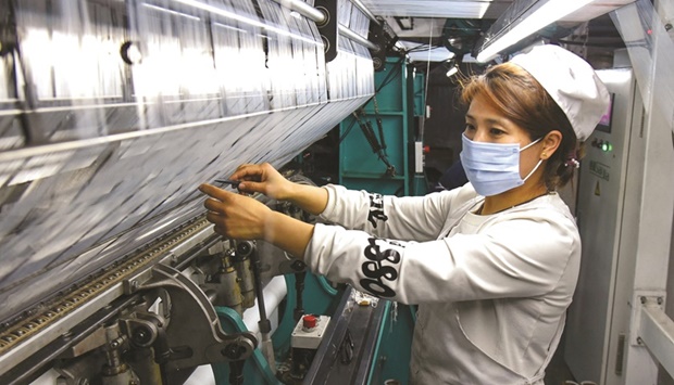 An employee works at a textile factory in Lianyungang, in Chinau2019s eastern Jiangsu province (file). Chinese factories often see a production lull in January and February as workers head home for the Lunar New Year holidays. Activity has also been affected this year by the governmentu2019s orders for steel plants to trim output to reduce air pollution ahead of the Winter Olympics in Beijing which begin on Friday.
