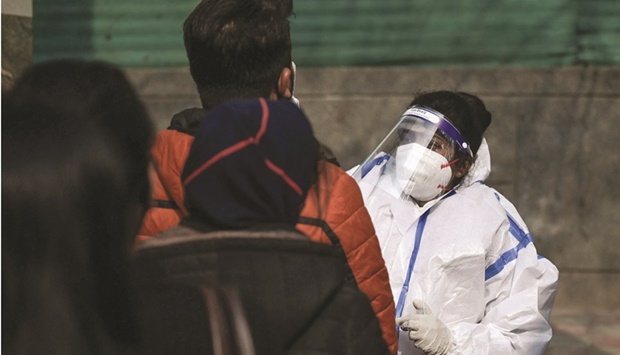 A health worker performs Covid-19 screening of people queued outside a metro station in New Delhi on Sunday. India added 33,750 new Covid-19 cases yesterday - the highest single day figure in more than three months - pushing the total confirmed tally to 34.9mn infections.