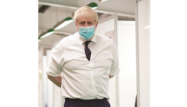 Prime Minister Boris Johnson, wearing a face covering to mitigate the spread of coronavirus, reacts during his visit to a Covid-19 vaccination hub in the Guttman Centre at Stoke Mandeville Stadium in Aylesbury, north west of London, yesterday.