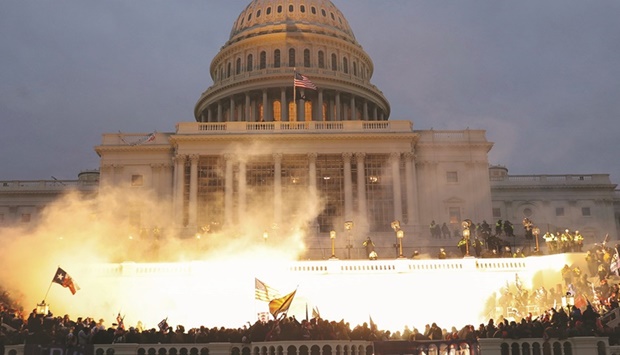 SPOTLIGHT: An explosion caused by a police munition is seen while supporters of former president Donald Trump gather in front of the US Capitol Building in Washington on January 6, 2021. (Reuters)