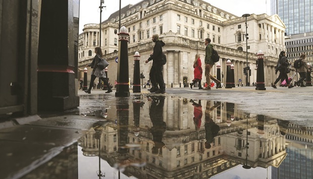 Pedestrians pass the Bank of England in the City of London. The BoE green quantitative easing programme is likely to have a muted impact on emissions and could even end up giving a boost to some of the most carbon-intensive companies, while cutting support for environmental industries, according to a new research published yesterday.
