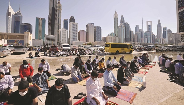 Men perform noon prayer in an area close to their workplace on the first working Friday in the Gulf emirate of Dubai, yesterday.