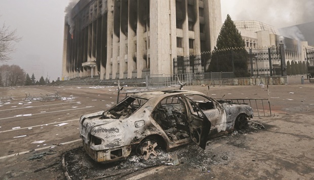 A burned car is seen in front of the mayoru2019s office building in Almaty.