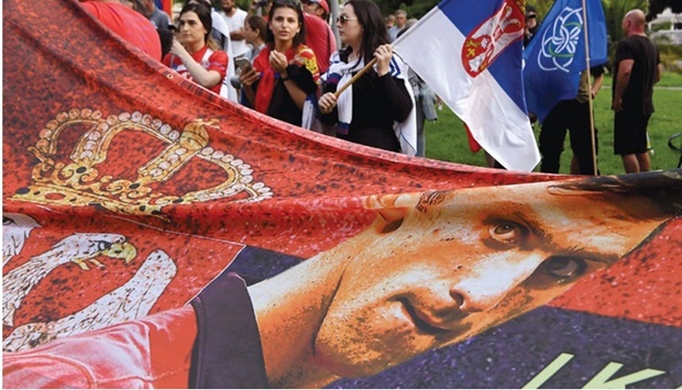 Members of the local Serbian community hold flags and banners outside a  government detention centre in Melbourne, where Novak Djokovic is staying. (AFP)