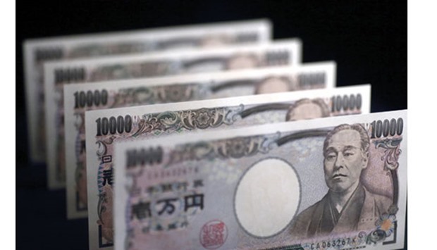 Japanese u00a510,000 notes are arranged for a photograph in Tokyo. JPMorganu2019s view clashes with the consensus among analysts for the yen to slide to 125 per dollar next year, which would complete a five-year decline of 38%.