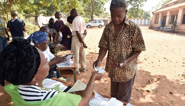 People receive their voter registration card in Bangui during a voter card distribution ahead of the countryu2019s presidential elections, yesterday.