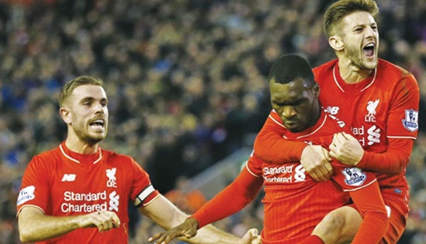 Christian Benteke (C) celebrates scoring the first goal for Liverpool with Adam Lallana and Jordan Henderson yesterday.