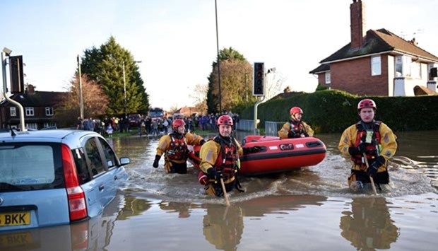 Members of the emergency services search for residents in need of rescue after River Foss burst its banks in York, northern England, on Sunday.