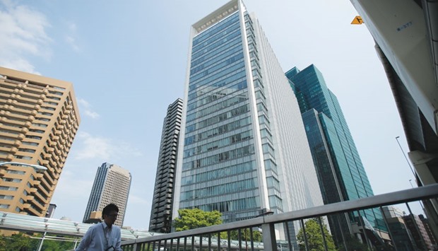 A pedestrian walks past the Ark Hills South Tower building, which houses the Takata Corp headquarters in Tokyo. The latest fatality in an accident in Pennsylvania linked to a Takata air bag highlights a flawed recall system that all-too-often fails to lead to critical repairs and can take years to complete, according to lawmakers and auto-safety advocates.