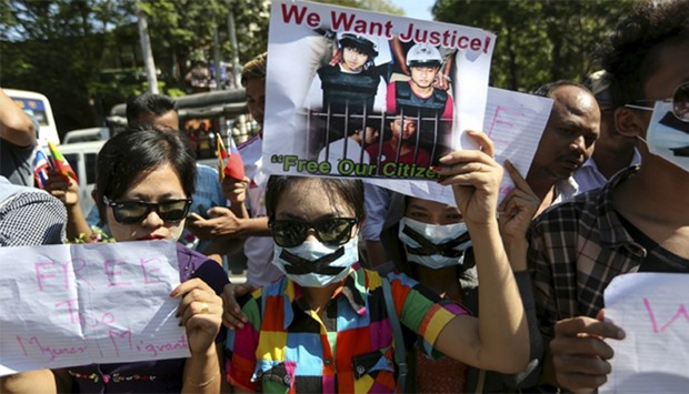 Protesters hold pictures of Zaw Lin and Win Zaw Htun, two Myanmar migrant workers in Thailand