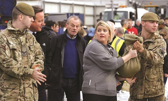 Prime Minister David Cameron talks to British soldiers and volunteers filling sand bags to assist with flood relief in York yesterday.
