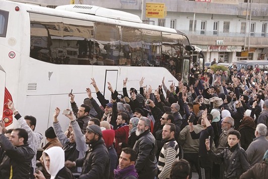People cheer and flash victory signs upon the arrival of a convoy carrying more than 125 fighters from the besieged rebel-held Syrian town of Zabadani at the Masnaa border crossing between Lebanon and Syria yesterday.