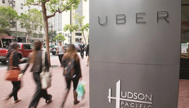 Foot traffic streams past Uber offices on Market Street in San Francisco. In 2016, on-demand service will quite literally be put on trial when a class-action lawsuit against Uber over worker misclassification goes before a jury in a US District Court.