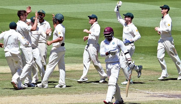 Australian bowler Mitch Marsh (second left) celebrates with teammates after dismissing West Indies batsman Marlon Samuels (third right) during the second cricket Test in Melbourne yesterday. (AFP)