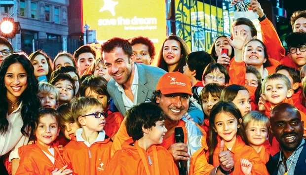 Former Italian footballer Alessandro del Piero (centre) and President of the International Centre for Sport Security Mohammed Hanzab (front centre) with Children in Times Square.