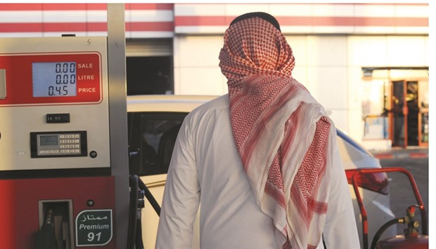 A Saudi man walks past a pump at a petrol station in the Jeddah on Monday. Authorities announced increases to the prices of fuel, electricity and water as part of a plan to restructure subsidies within five years.
