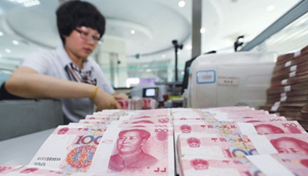 A teller counts yuan banknotes in a bank in Lianyungang. China has scaled back efforts to prop up the yuan after the International Monetary Fund included the currency in its Special Drawing Rights.