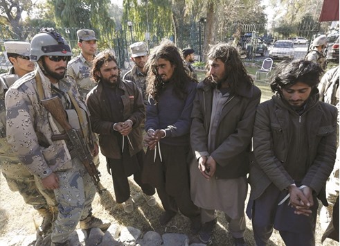 Taliban militants who were arrested by Afghan border police, stand during a presentation of seized weapons and equipment to the media in Jalalabad on December 29.