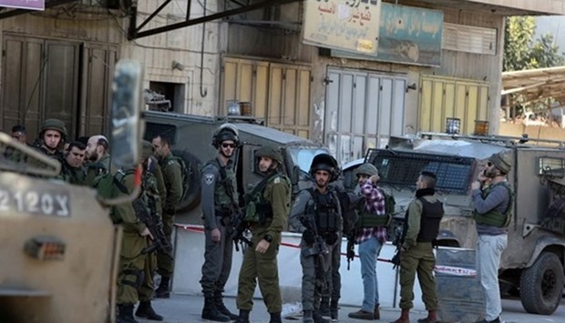 Israeli security forces gather at the site of a reported stabbing attack near the Huwara checkpoint near the West Bank city of Nablus, on December 27, 2015. AFP