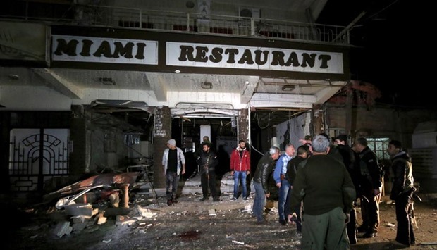 Residents inspect damage from a suicide bomb in Qamishli, Syria. Twin suicide bombings hit two restaurants in a Kurdish-controlled city in northeastern Syria on Wednesday, killing or wounding dozens of people.