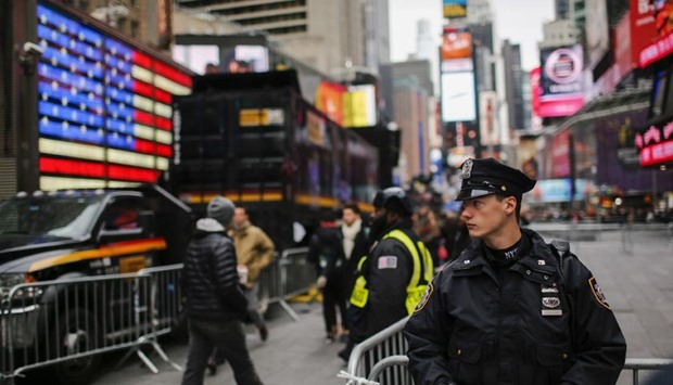 A New York police officer keeps an eye on people at Times Square before New Year's Eve celebrations in the city.