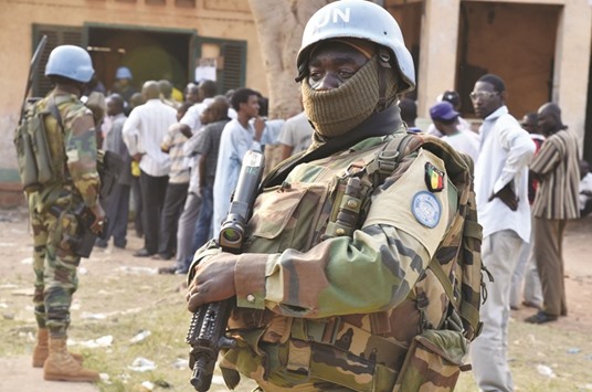 Senegalese UN peacekeeping forces stand guard as people wait to vote at a polling station during presidential and legislatives elections in the streets of the Muslim PK-5 district of Bangui on Wednesday.
