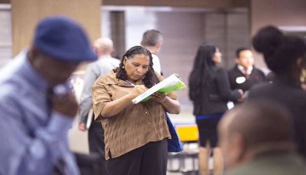 A woman fills out her application during a job fair for the homeless at the Los Angeles Mission in the Skid Row area of Los Angeles. Initial claims for state unemployment benefits rose 20,000 to a seasonally adjusted 287,000 for the week ended December 26, the US Labour Department said yesterday.