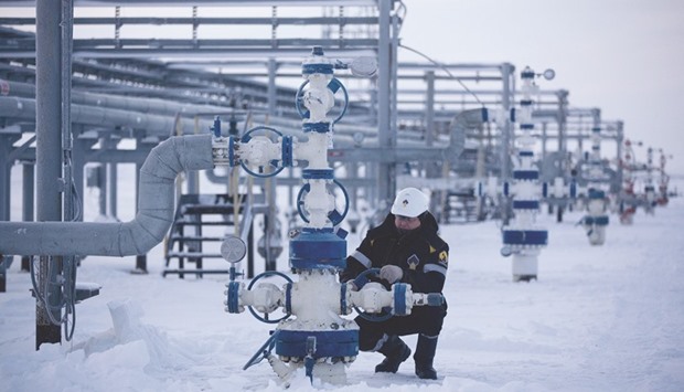 An oil worker turns a control wheel on a cluster well on the Russkoye heavy crude oil field, operated by Rosneft, in the Yamalo-Nenets region of East Siberia. Russia is expected to shoulder half of the non-Opec cut, but yesterday Moscow signalled there were snags that needed to be addressed before a deal could be reached.