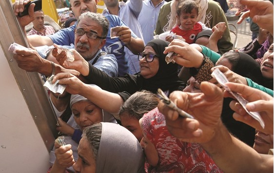Egyptians gather to buy subsidised sugar from a government truck after a sugar shortage in retail stores across the country in Cairo on October 14. The downturn that followed the floating of the pound is hardly a surprise; economists and officials agree that re-engineering an economy battered by five years of unrest will mean some pain.