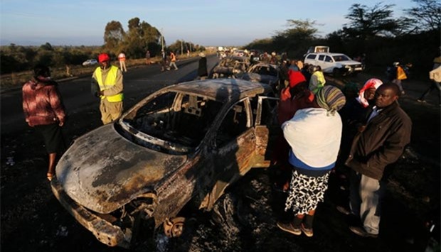 Relatives and civilians look at the wreckage of a burnt car after a fireball from a tanker engulfed several vehicles and killed several people, near the Rift Valley town of Naivasha, west of Kenya's capital Nairobi, on Sunday.