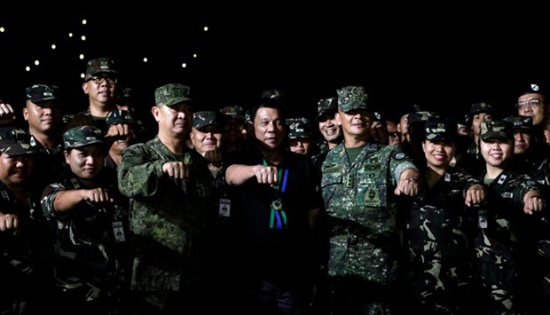Philippine President Rodrigo Duterte makes a fist bump with soldiers during a visit to Camp Servillano S. Aquino in San Miguel, Tarlac, Philippines