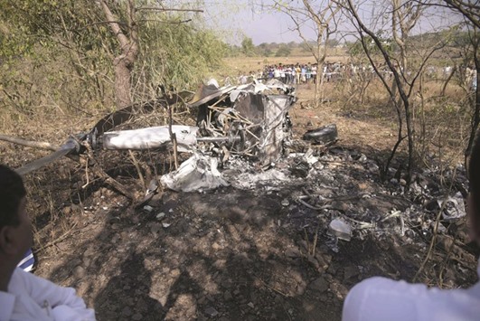 Onlookers gather near the wreckage of a helicopter in an open field in Goregaon yesterday.