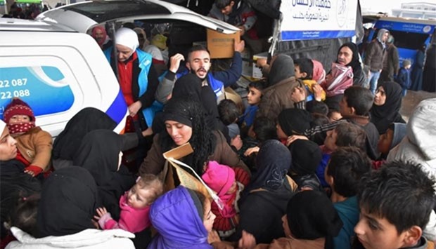 Syrians who fled from rebel-held areas in east Aleppo receive food at a warehouse in Duweirineh, a small village on the eastern outskirts of the embattled city, on Thursday.