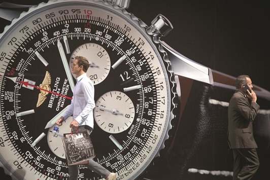 Pedestrians walk past a Breitling advertisement on Fifth Avenue in New York. The 132-year-old watchmaker is one of the larger Swiss watch brands thatu2019s still independent while most others have been acquired by Swatch Group, Richemont, LVMH and Kering.