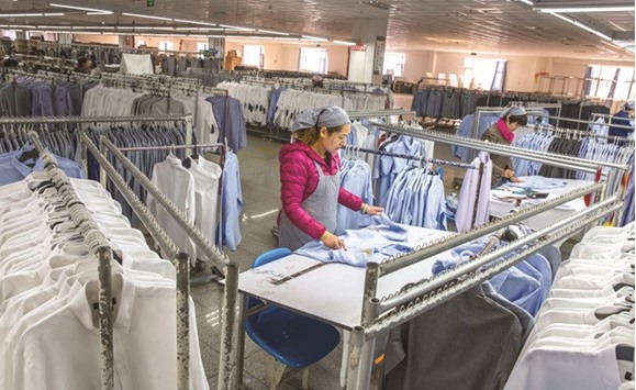 A woman works in a shirt factory in Nantong, in Chinau2019s Jiangsu province yesterday. Chinau2019s official PMI rose to 51.7 in November from 51.2.