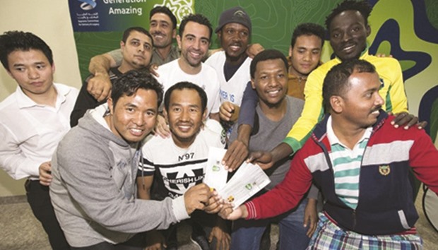Xavi poses with workers at Labour City.