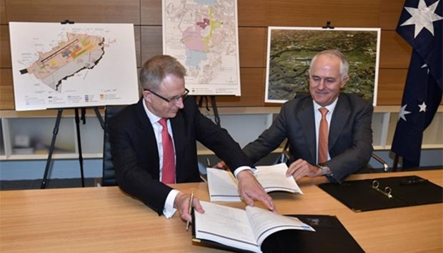 Australia's Prime Minister Malcolm Turnbull and Urban Infrastructure Minister Paul Fletcher exchange documents as they sign off on plans for a second international airport in Sydney on Monday.
