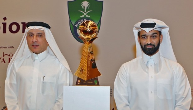 CEO of Qatar Airways, Akbar al-Baker (L), and Secretary General of the Qatar 2022 Supreme Committee, Hassan al-Thawadi, pose with the cup of the match during a press conference in Doha