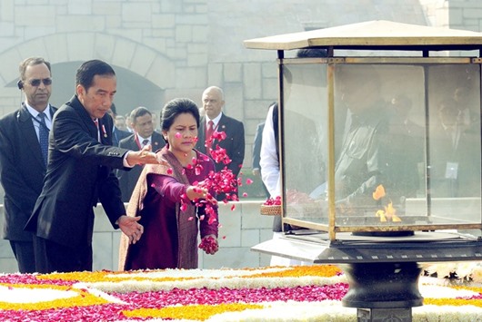 Indonesian President Joko Widodo and his wife HJ Iriana are watched by officials as they pay their respects with floral tributes at the memorial of Mahatma Gandhi at Rajghat in New Delhi yesterday.