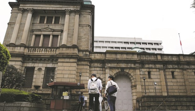 Men walk towards the Bank of Japan building in Tokyo. The BoJ is likely to give a more upbeat view of the economy at next weeku2019s rate review, sources say, as a pick-up in emerging Asian demand and positive signs in private consumption improve prospects for a solid, export-driven recovery.