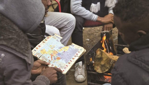 A group of Eritrean and Sudanese migrants staying at Herrouu2019s camp discuss their next move.