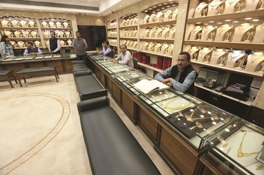 Salespersons wait for customers at a gold jewellery showroom in Chandigarh. Anticipating curbs on gold imports, banks and other nominated agencies ramped up overseas purchases in mid-November, but demand plunged by the third week of the month due to the shortfall of currency notes, dealers said.