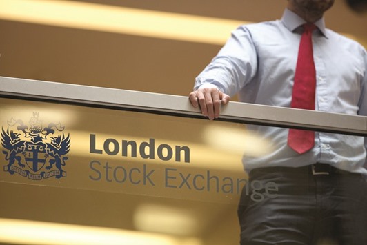 An employee leans on a glass wall above the main atrium of the LSE headquarters in London. The FTSE 100 index ended the day down 0.5% at 6,752.93 points yesterday.