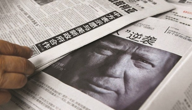 This photo taken on November 10 shows a newspaper featuring a photo of Trump at a newsstand in Beijing. China has warned Trump that the One China policy is u2018non-negotiableu2019 and dropping it could lead to Beijing supporting US enemies.