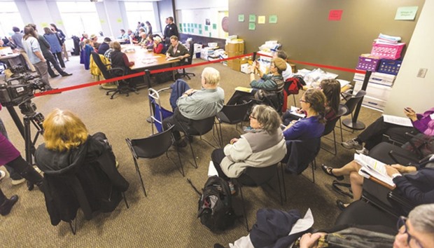 Observers watch as tabulators in Dane County work on recounting presidential ballots yesterday in Madison, Wisconsin.