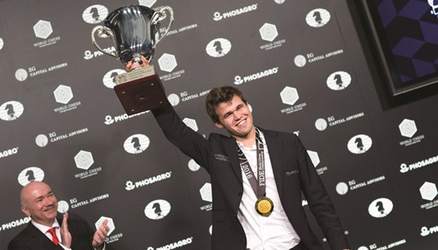 Norwegian chess grandmaster Magnus Carlsen pose with the trophy after defeating Russian grandmaster Sergey Karjakin at the World Chess Championship in New York. (AFP)