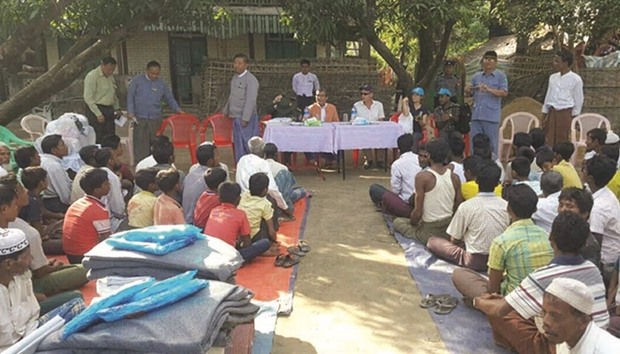 Handout photograph released by Myanmar State Counselloru2019s Office shows Muslim minority residents of Maungdaw located in Rakhine State, gathering to receive humanitarian aid from UNHCR officiated by Rakhine State and UNHCR officials.