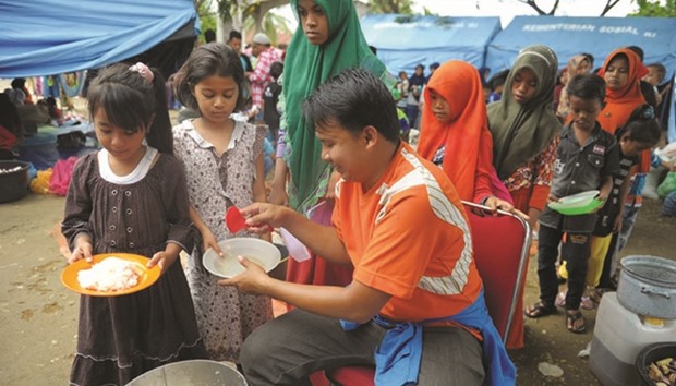 Displaced people queue for their meal at a shelter after the 6.5 magnitude earthquake in Pidie Jaya, Aceh province, yesterday.