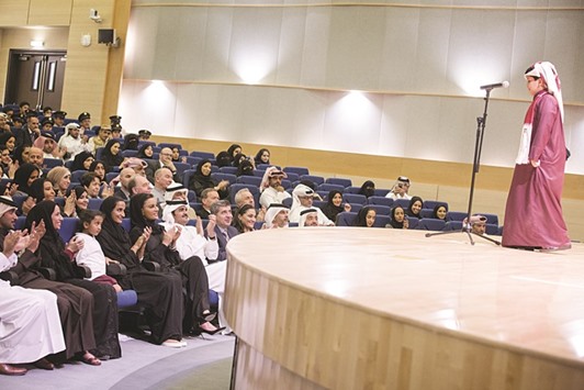 A Qatar Academy student recites a Qatari poem at the event.